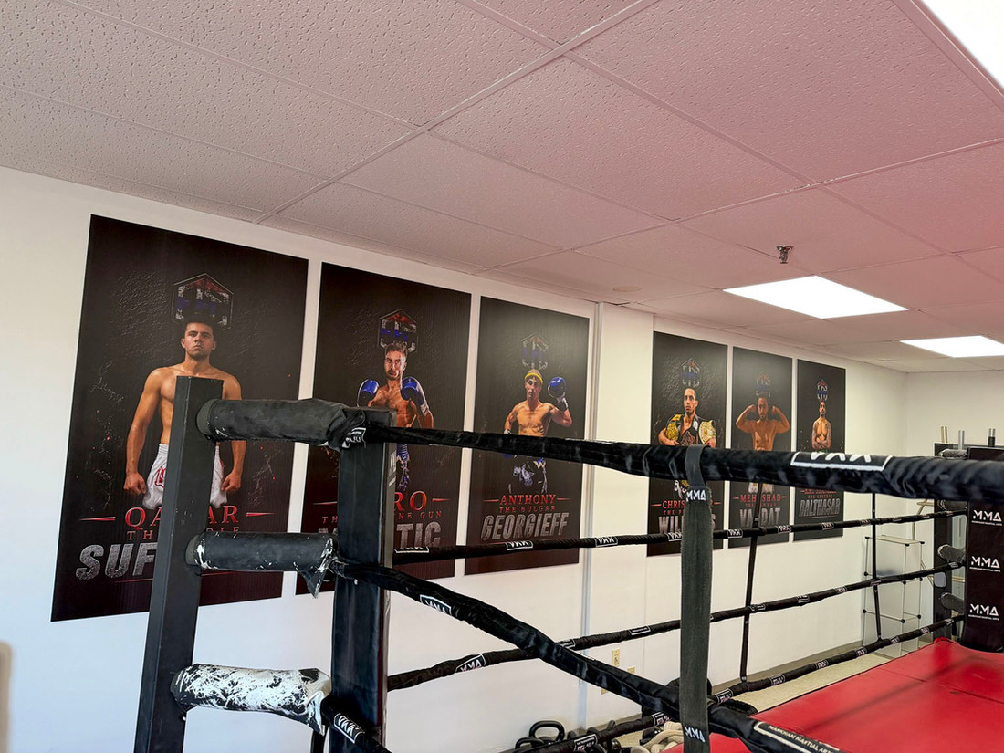 Boxing ring and fighter portrait wall inside Elite Fight Club