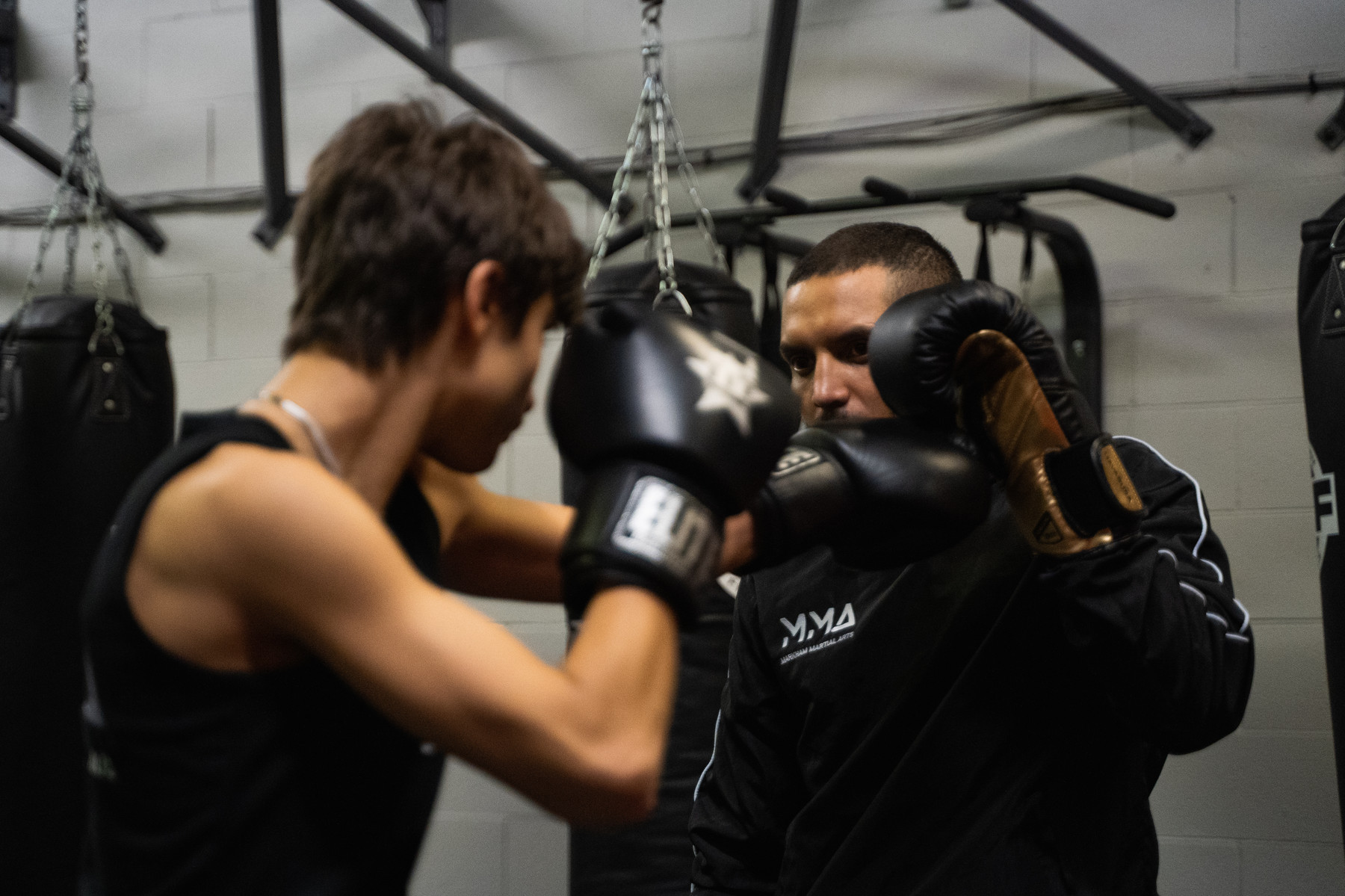 A student works on Muay Thai pad drills with a coach at Elite Fight Club.